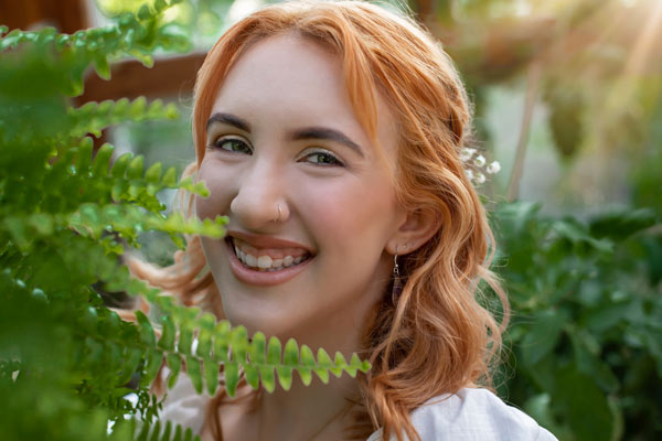 Redhead Senior Girl Smiling Behind Green Ferns in Franklin TN | Senior Photos Moments By T
