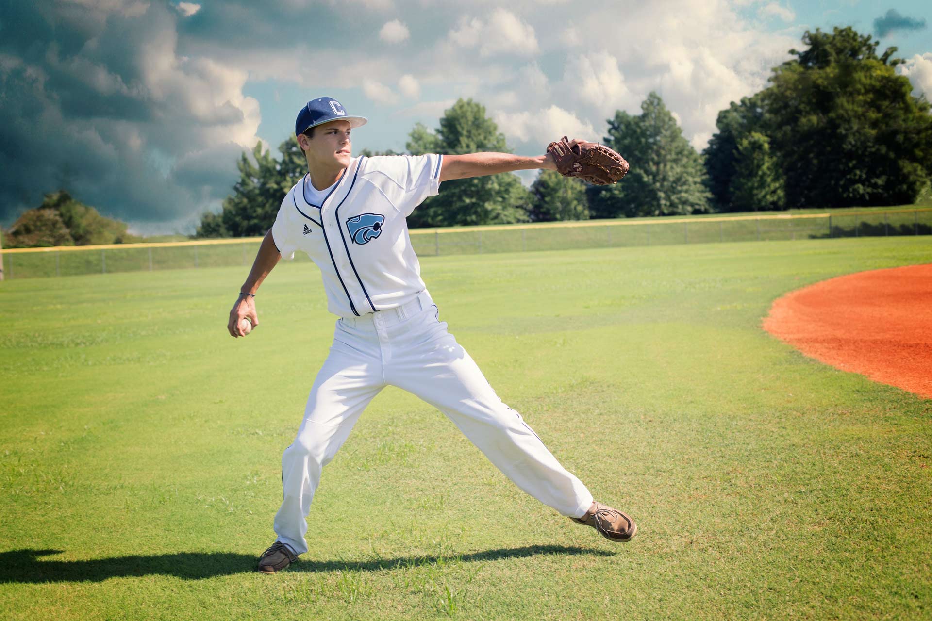 baseball player throwing a ball during a professional senior photography session at Moments By T, Franklin Tennessee